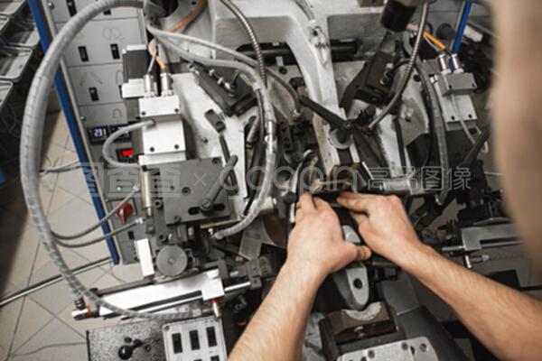 男人用特殊的機械工具制鞋。鞋廠的輸送機,有鞋底和鞋底。